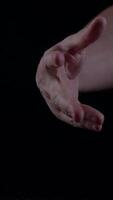 Hand holding a ripe fig with a dark background showcasing intricate details video