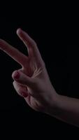 Hand forming a victory sign with quotation marks against a dark background expressing empowerment and confidence in modern communication video