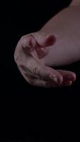 Man's hand displays fresh fig against dark background during evening setting video