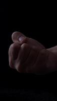 Male hand displaying middle finger gesture against a dark background to express defiance or frustration in a personal context video