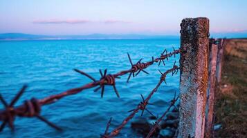 Barbed wire fence by the sea photo