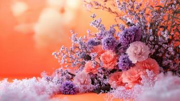Purple and pink flowers are arranged in a vase on an orange background photo