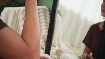 Side view of a woman carefully drawing her eyebrows while looking at her reflection in the mirror video