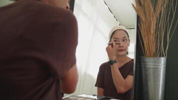 Woman Refining Nose Shadow with Makeup Brush in Front of Mirror video