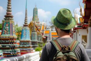 Rear view of a traveler man with backpack at Thailand pagoda photo