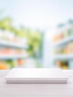 A minimalist white platform atop a textured wooden surface set against a softly blurred backdrop photo