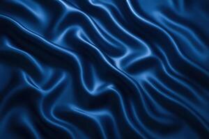 A close-up view of deep blue satin fabric with smooth, flowing folds. The texture appears soft and luxurious, showcasing the sheen of the material. photo