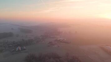 Aerial view of a farm and fields at sunrise video