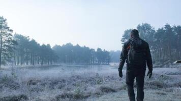 A man with a backpack standing in the middle of a field video