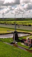 A windmill and a house on a green field video