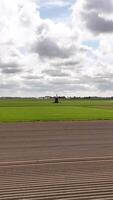 A tractor is driving on a field with a green field video