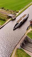 A boat is traveling down a canal in a green field video