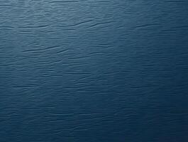 A deeply textured, solid dark blue surface features subtle, wavy horizontal patterns across the frame, creating a rich and uniform backdrop photo
