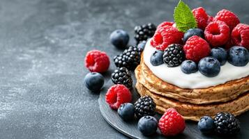 Pancakes with berries and cream on a black background photo