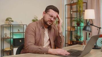cansado eu vou caucasiano homem usando computador portátil e sofrimento a partir de dor de cabeça problema tensão sentado às mesa video