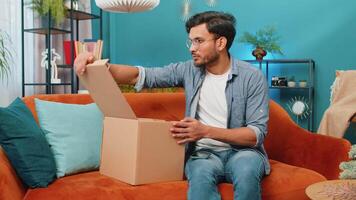 Angry dissatisfied shopper Indian man unpacking parcel feeling upset, confused, wrong delivery video