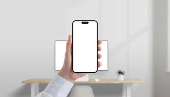 Smartphone with blank white screen held in hand in modern office, desktop computer in background, perfect for mobile UI mockup photo