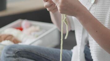 A closeup shot of hands expertly knitting with soft green yarn, showcasing the intricate artistry involved in this craft, all set within a cozy environment that promotes relaxation and mindfulness video