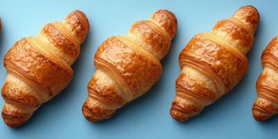 Freshly baked croissants arranged on a light blue surface for a delightful breakfast display photo