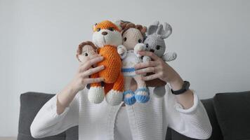 A joyful person holds a delightful and colorful array of intricately crocheted soft toys, which perfectly capture the charm, boundless imagination, and pure joy that embodies the essence of childhood video