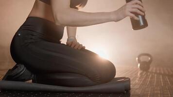 ein Individuell Übergänge zwischen Yoga posiert auf ein Matte, nippen von ein stilvoll Wasser Flasche, alle im ein still Atmosphäre Das fördert Achtsamkeit und Entspannung während ihr Fitness Routine video