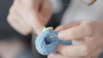 Fingers deftly handle soft blue yarn, demonstrating advanced techniques in crafting, highlighting creativity and tactile engagement in the captivating realm of textile art and design video