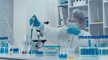 un dedicado científico en protector engranaje cuidadosamente prepara soluciones mientras conductible avanzado experimentos en un moderno laboratorio, exhibiendo alto normas de científico investigación y innovación video