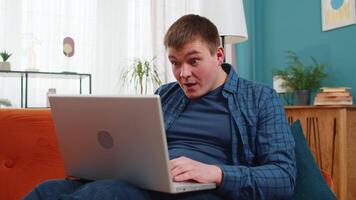 Surprised amazed man using laptop computer, receive mail good news message wow shocked win app game video