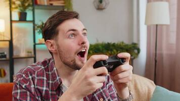 Man using joystick controller playing console television game fun enjoying at home room sofa video