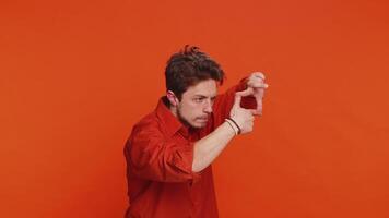 Man photographer gesturing picture frame with hands, looks through fingers focusing cropping image video