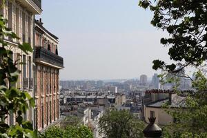Beautiful view of Parisian rooftops from a hillside in warm sunlight, showcasing the city's iconic architecture and skyline photo