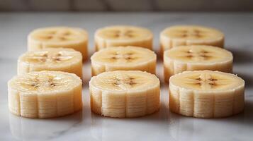 Sliced bananas arranged neatly on a marble countertop in a bright kitchen photo