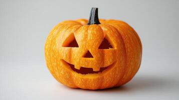 Pumpkin carved with a cheerful face sits against a neutral background for Halloween decoration in autumn photo