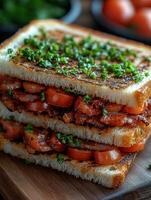 Close up of sandwich with bacon, salami, prosciutto and fresh vegetables on rustic wooden cutting board. Club sandwich concept. photo