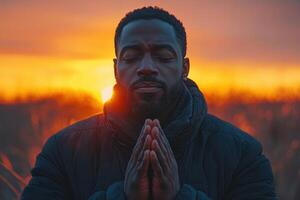 a man praying in front of the sun photo