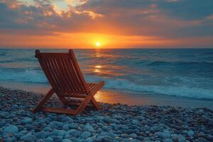 chair sits on the beach at sunset photo