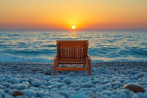 a chair sits on the beach at sunset photo