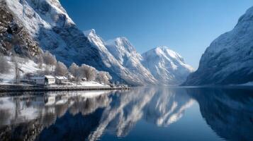 Serene Winter Landscape with Snow-Capped Mountains and Calm Lake Reflecting Blue Sky and Peaceful Village in Norway photo