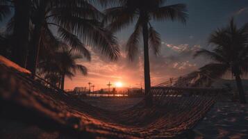 Sunset Over Tropical Beach with Palm Trees and Hammock in Tranquil Evening Scene photo