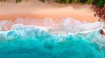Aerial View of Turquoise Ocean Waves Gently Lapping Against Sandy Beach and Rocky Shoreline Surrounded by Lush Greenery photo