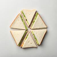 Triangular sandwiches arranged in circular pattern on light background with copy space photo