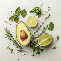 Fresh avocado half with lime and assorted herbs on light background in vibrant arrangement with copy space photo