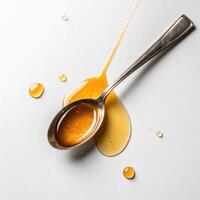 Metal spoon with honey and drops on white surface in minimalistic style with copy space photo
