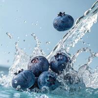 Fresh blueberries splashing in water with a lively feel on a light blue background photo