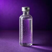 Clear glass bottle with water bubbles on dark purple background with refreshing mood and copy space photo