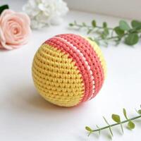 Crocheted colorful ball with a playful design and soft texture on a light background for children's toys photo