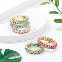 Colorful stacked beaded bracelets with gold accents on a light background with tropical leaves and copy space photo