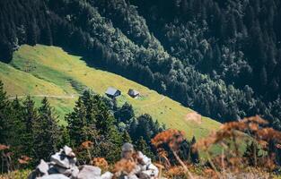 a small house sits on a hillside in the mountains photo