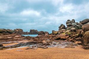 a rocky beach with some rocks and water In Brittany photo