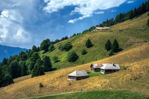 a small house sits on a hill in the mountains photo